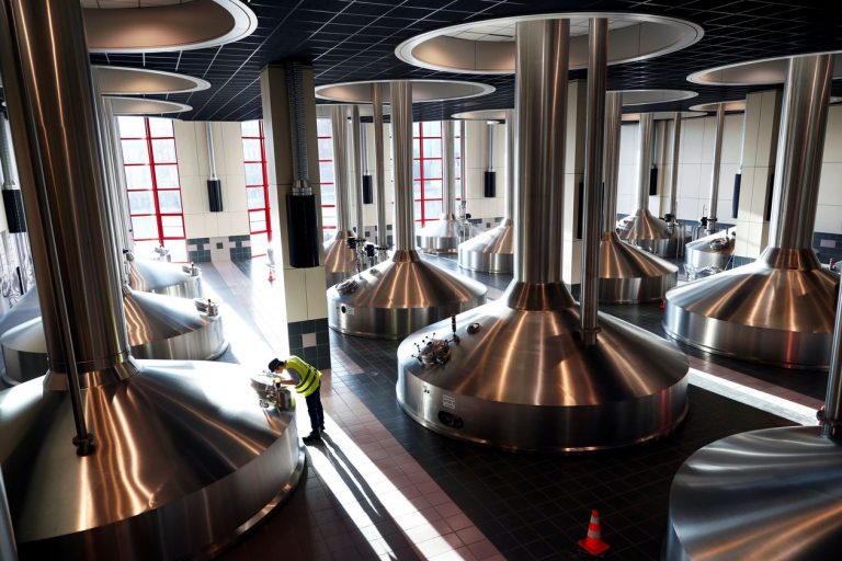 A worker inspecting vats at an Anheuser-Busch InBev brewery in Leuven, Belgium.